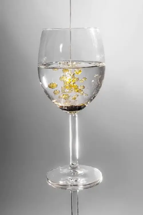 pouring castor oil in glass of water